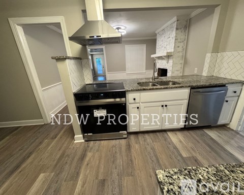 A kitchen with a sink, stove, and oven with the text "NDW PROPERTIES" on the wall.