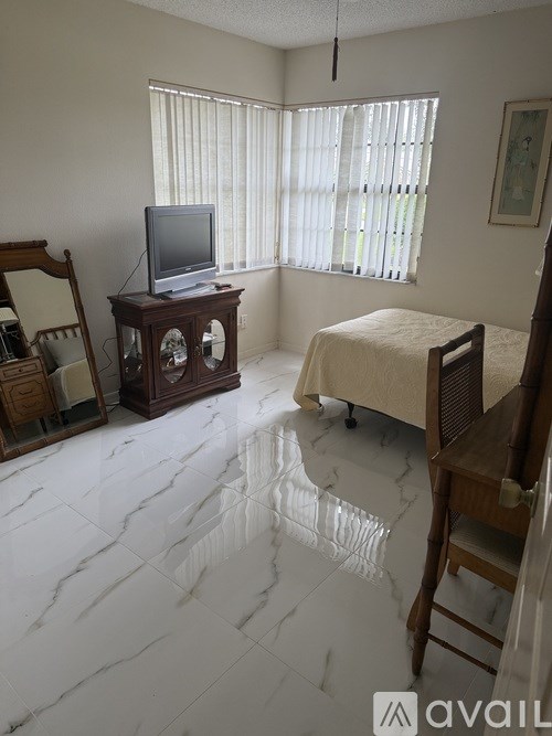 A bedroom with a bed, a television, and a wooden cabinet.