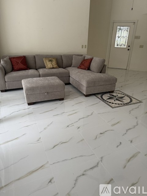 A living room with a grey couch and ottoman.