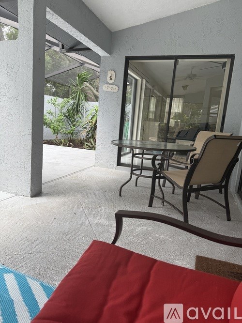 A patio with a glass table and chairs.