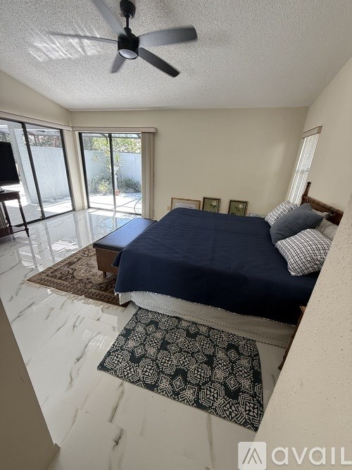 A bedroom with a bed, a ceiling fan, and a rug.