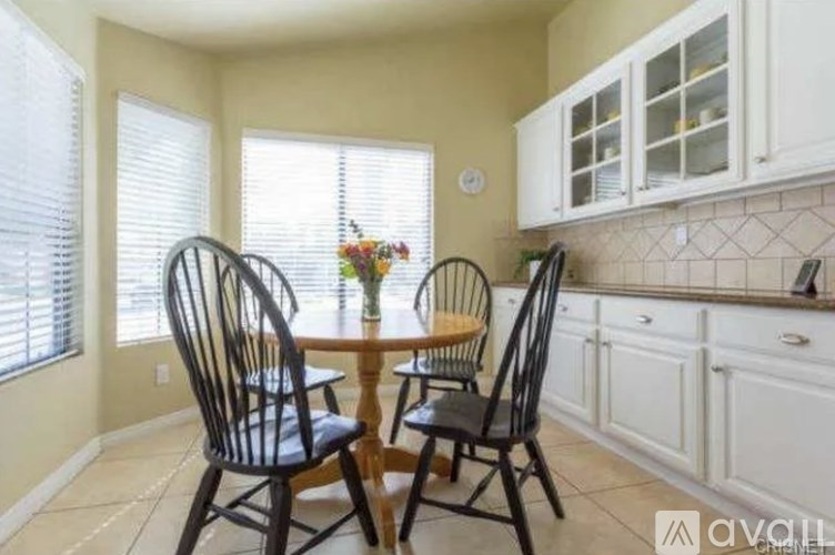 A dining room with a table and chairs.