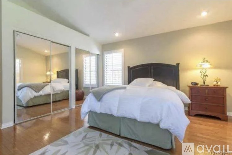 A bedroom with a large bed and a mirror on the wall.