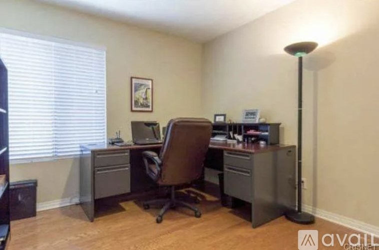 A room with a desk, chair, and computer.