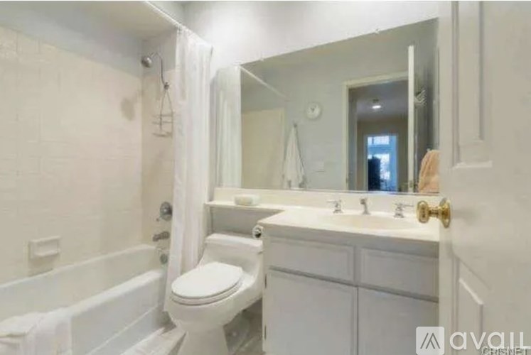 A white bathroom with a toilet, sink, and bathtub.