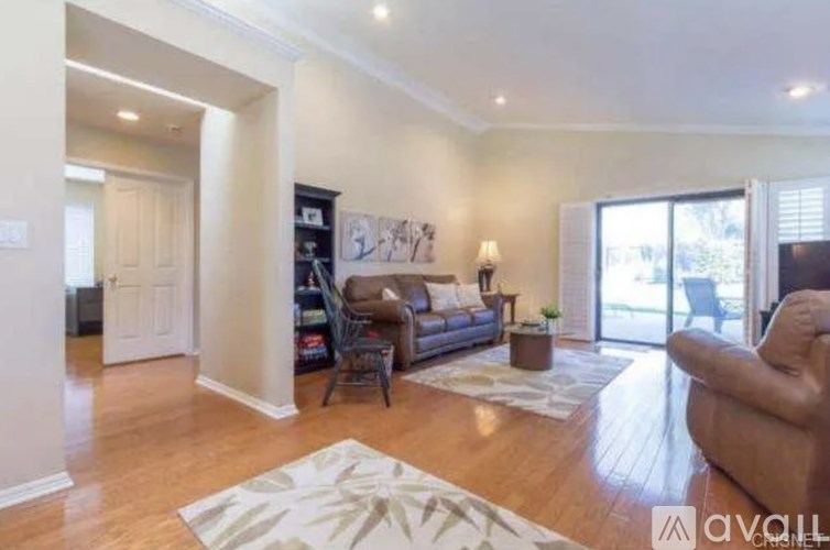 A living room with a couch, a chair, and a rug.