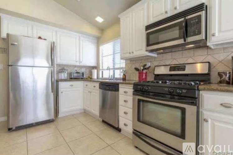 A kitchen with white cabinets and stainless steel appliances.
