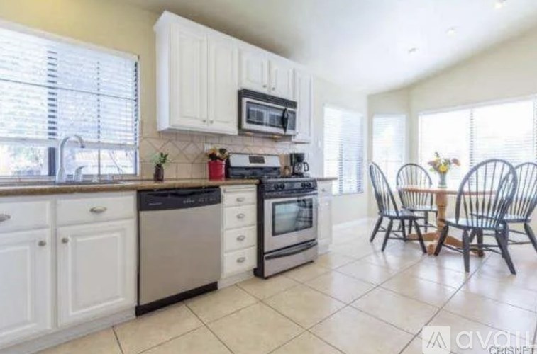 A kitchen with white cabinets and a black stove top oven.