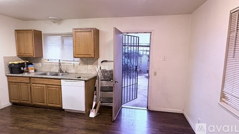 A kitchen with wooden cabinets and a white dishwasher.