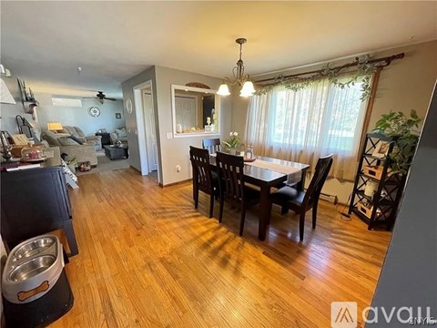 A dining room with a wooden table and chairs.