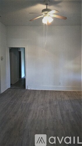 A room with a ceiling fan and a door.