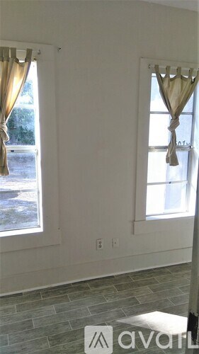 A room with two windows and a tiled floor.