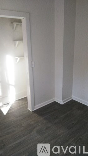 A room with a wooden floor and a white door.