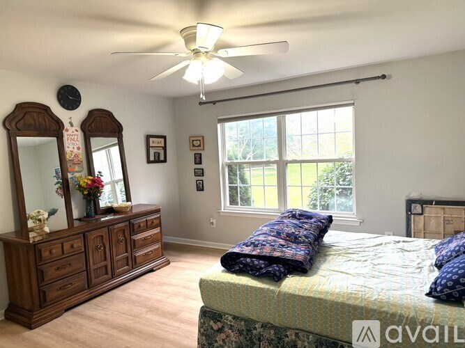 A bedroom with a bed, dresser, and mirror.