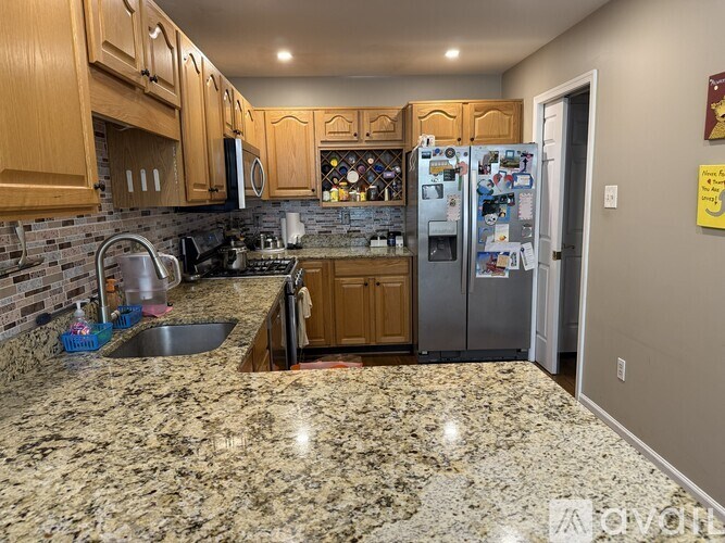 A kitchen with granite countertops and wooden cabinets.