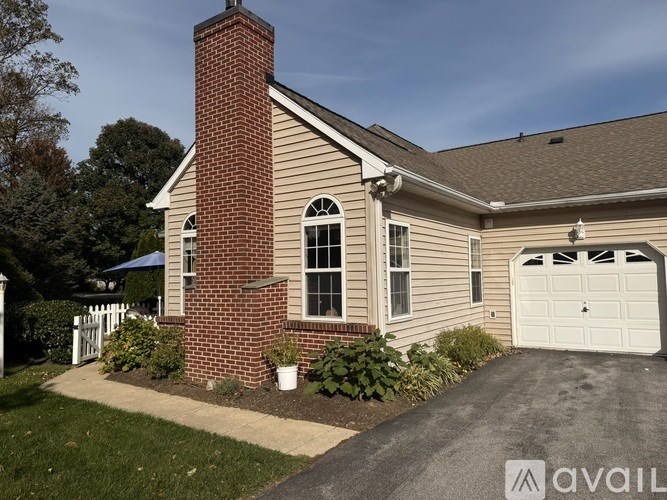 A house with a brick chimney and a garage door.