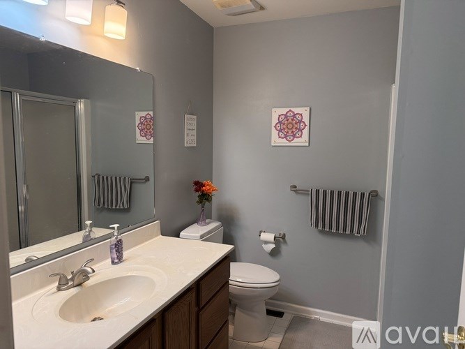 A bathroom with a toilet, sink, and mirror.