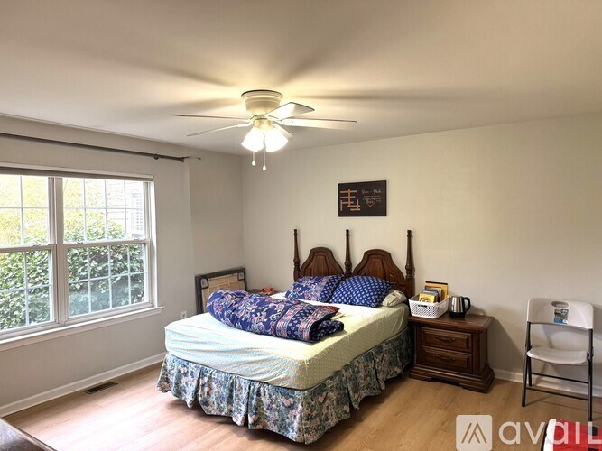 A bedroom with a bed, nightstand, and window.