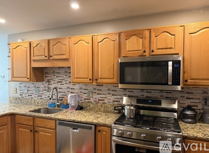 A kitchen with wooden cabinets and a granite countertop.