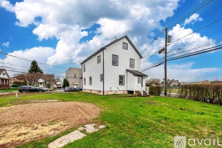 A white house with a yard in front of it.