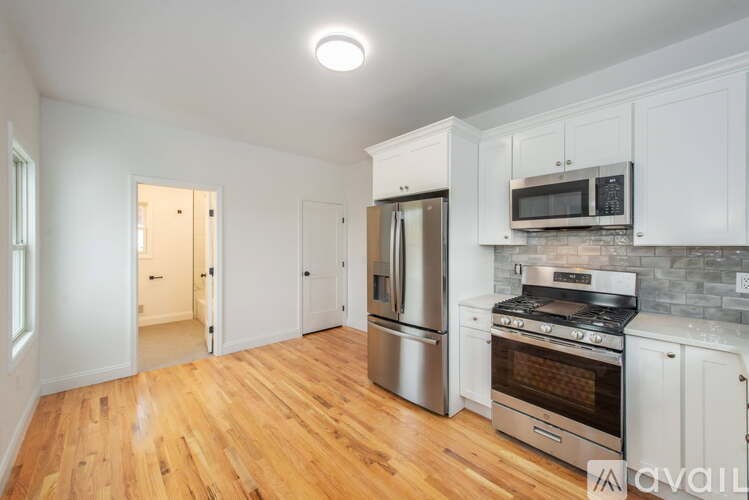 A kitchen with wooden floors and stainless steel appliances.