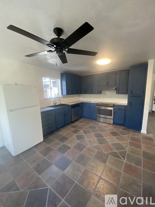A kitchen with a fan and tile flooring.