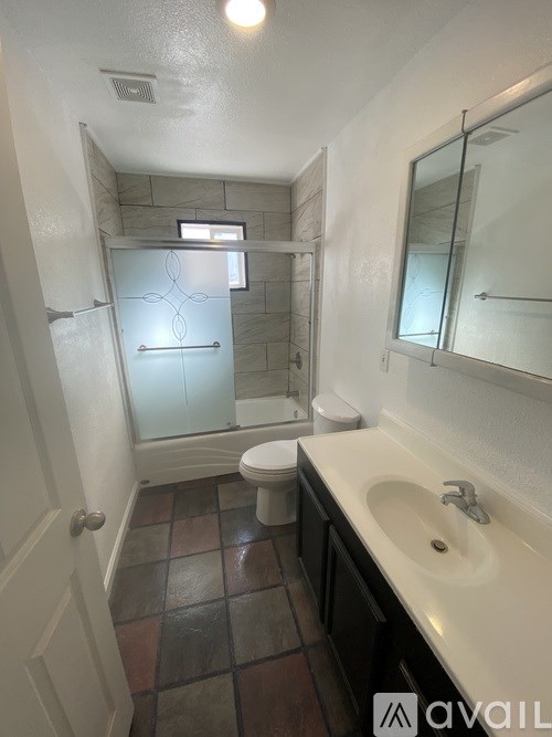 A bathroom with a toilet, sink, and shower.