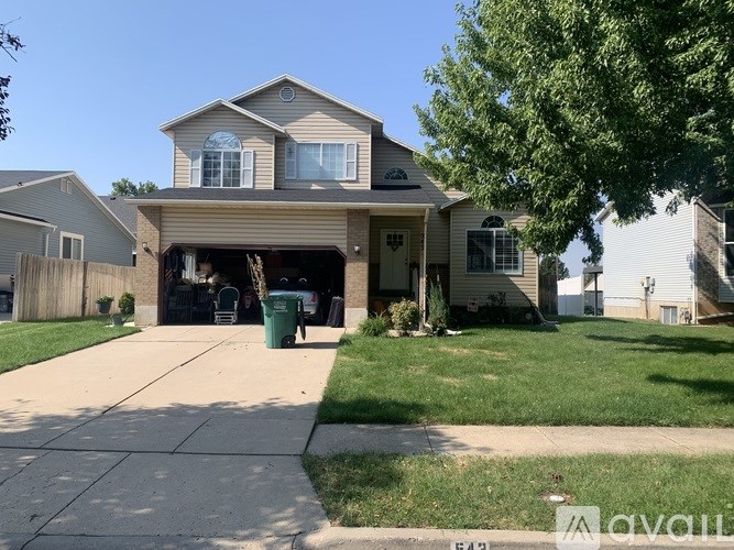 A house with a garage and a driveway in front.