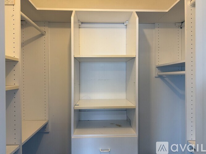 A white cabinet with a drawer is open in a room.