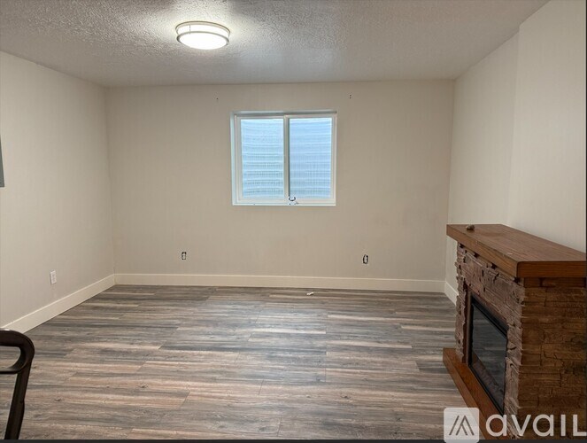 A room with a fireplace and a window with blinds.