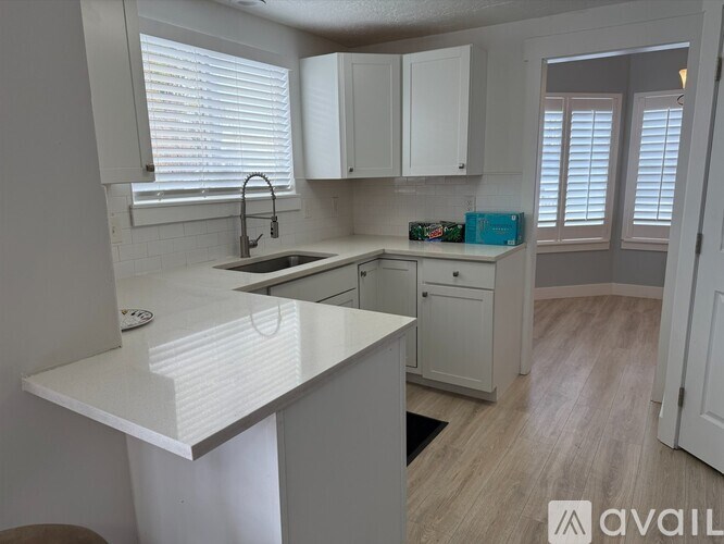 A kitchen with white cabinets and a white countertop.