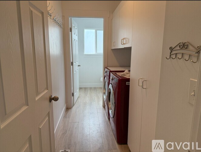 A hallway with a washing machine in the corner.