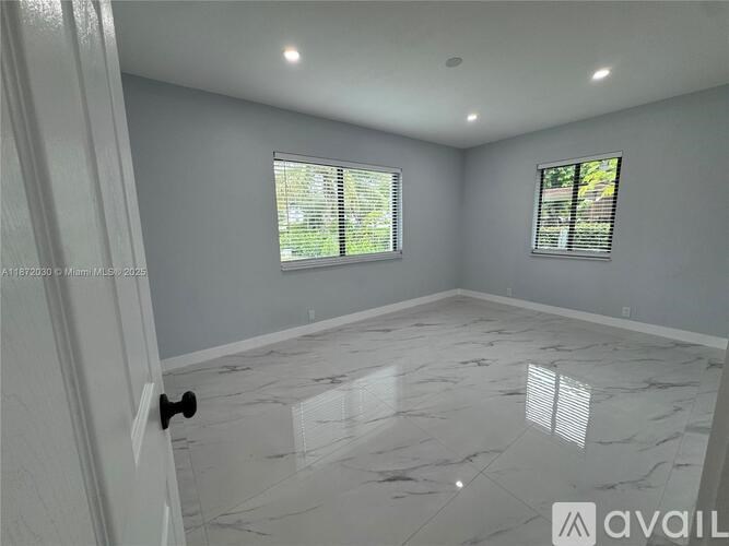 A room with a marble floor and two windows.