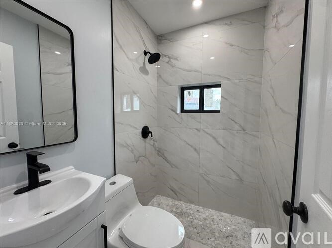 A bathroom with a marble wall and a white toilet.