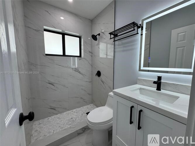 A bathroom with marble walls and a white toilet.