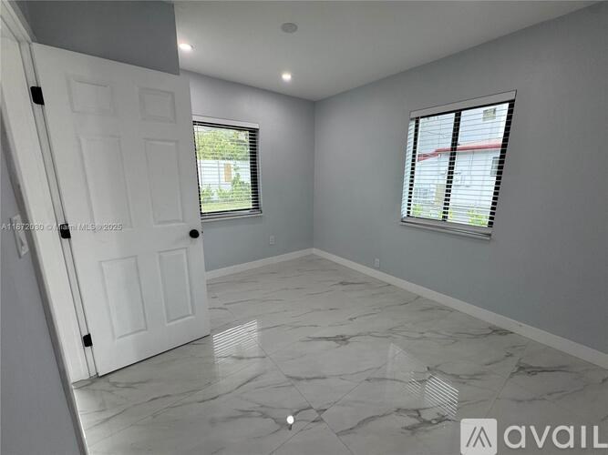 A room with a marble floor and a window with blinds.