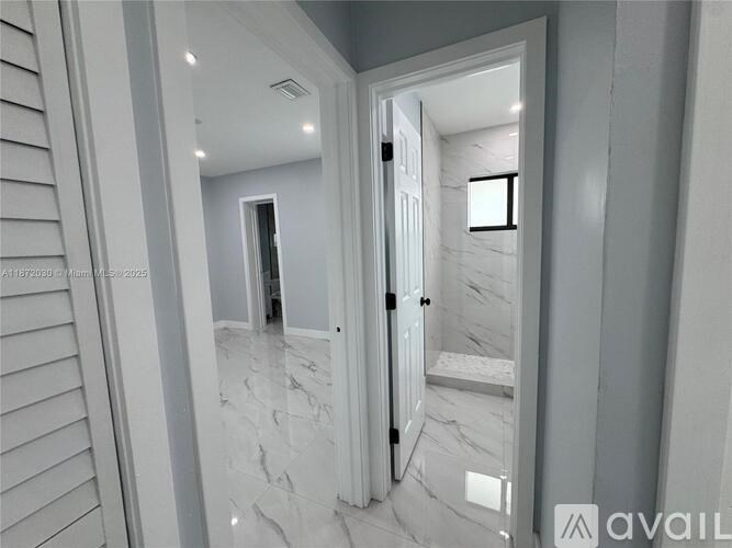 A bathroom with a marble floor and white walls.