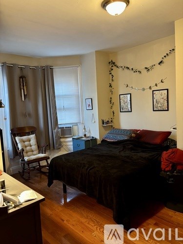 A bedroom with a bed, chair, and decorations.