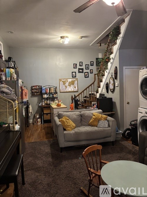 A living room with a grey couch and a wooden chair.
