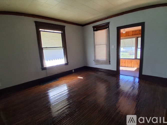 A room with wooden floors and two windows.