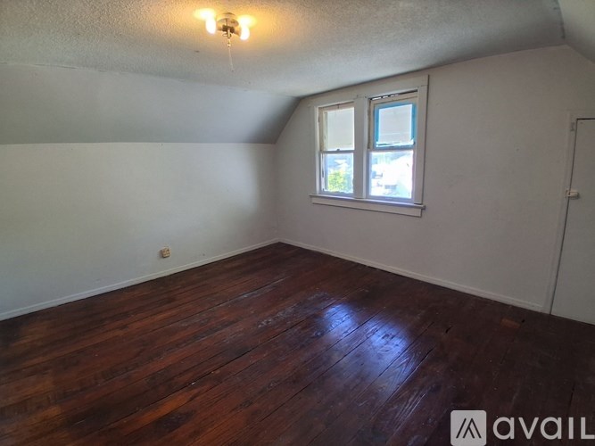 A room with wooden floors and a window.