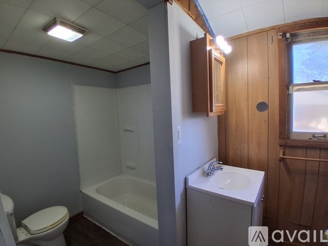 A bathroom with a toilet, sink, and bathtub.