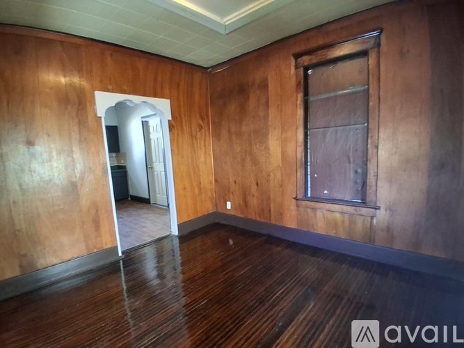 A room with wooden walls and floor and a window.