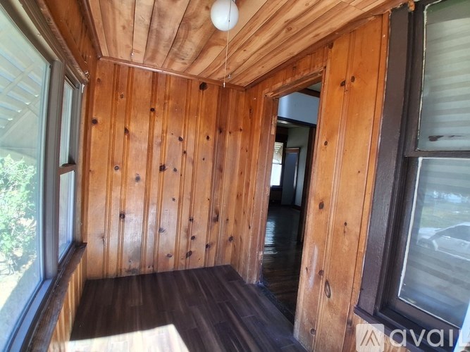 A wooden room with a window on the right side.