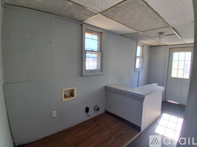 A room with a window and a door is available for rent.