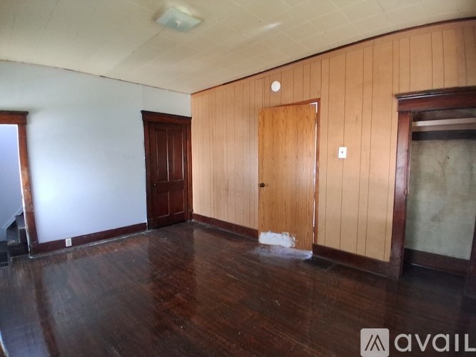 A room with wooden floors and a brown door.