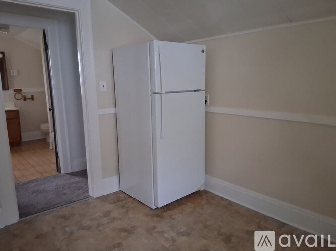 A white refrigerator in a room with beige walls.
