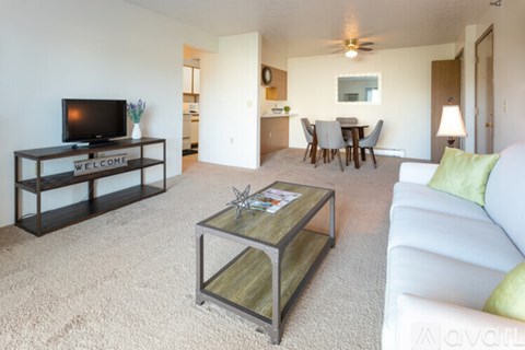 A living room with a white couch and a glass coffee table.