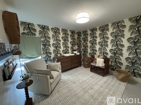 A living room with a white couch and a wallpapered wall.