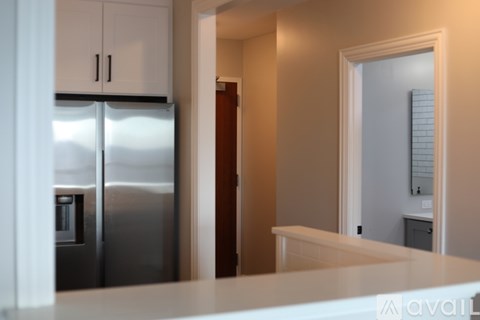 A kitchen with a stainless steel refrigerator and white cabinets.